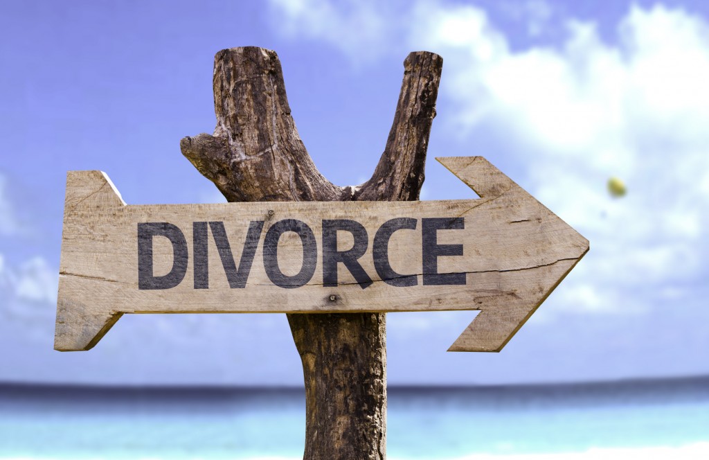 Divorce wooden sign with a beach on background